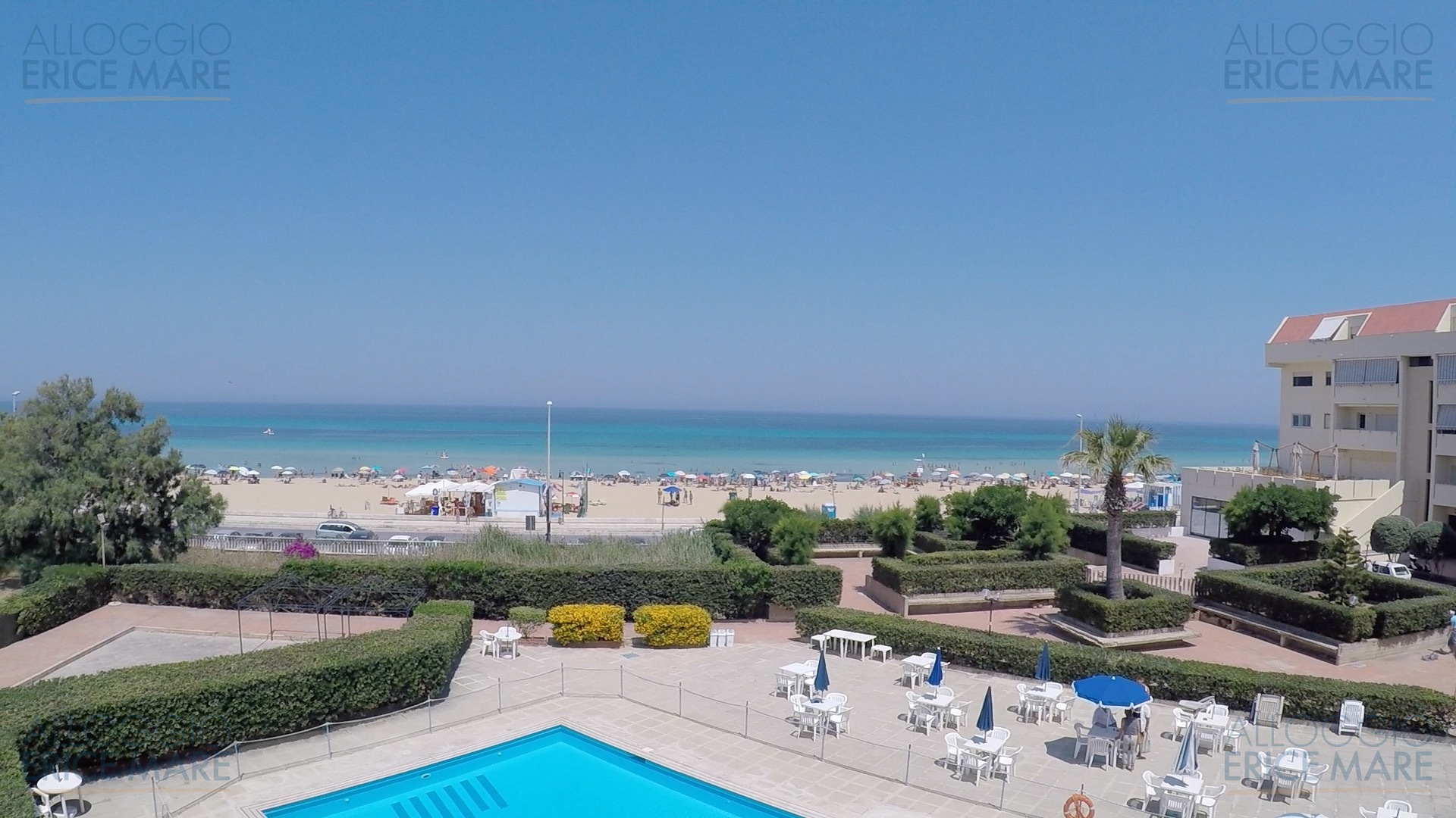 Vista panoramica dall’alto della piscina del residence con la spiaggia e il mare di San Giuliano sullo sfondo