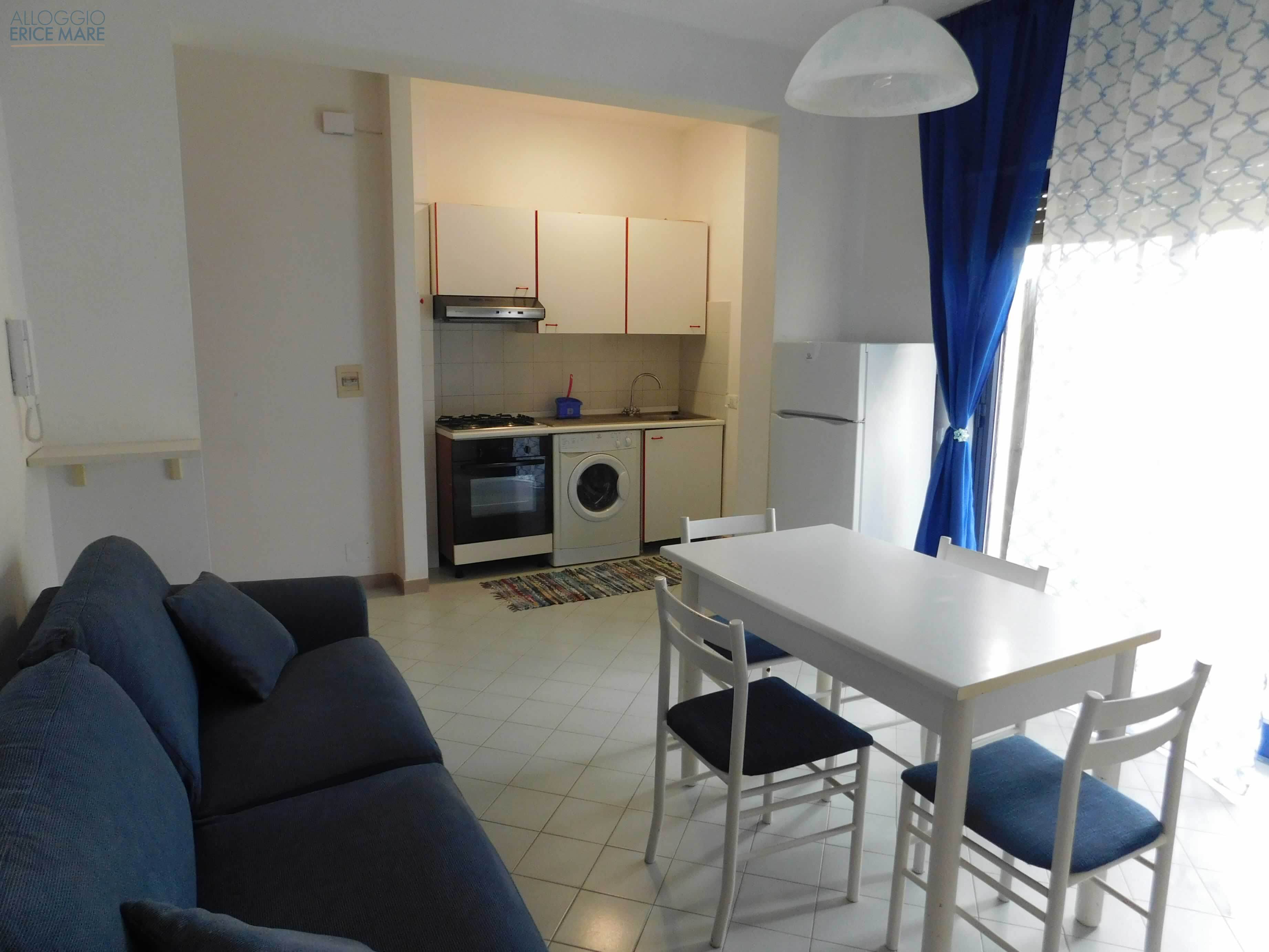 Zona giorno con cucina a vista e tavolo da pranzo